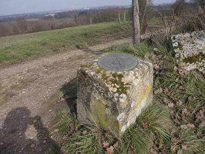 Borne géodésique ancienne au bord d'un chemin